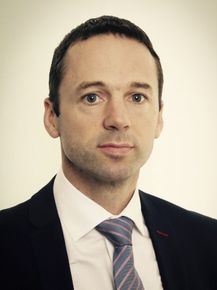 A man in a suit and tie is looking at the camera