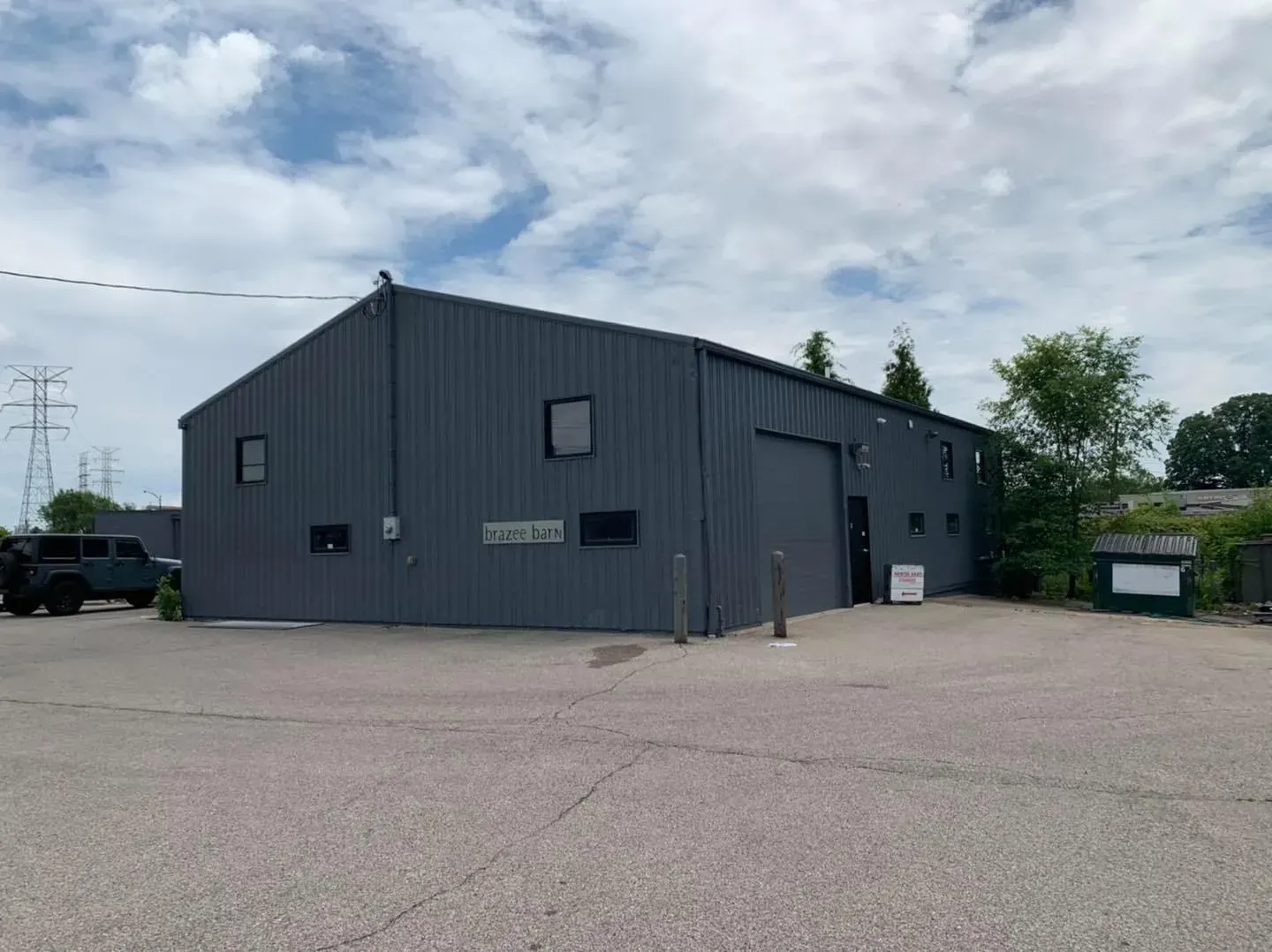 A large gray building with a jeep parked in front of it.