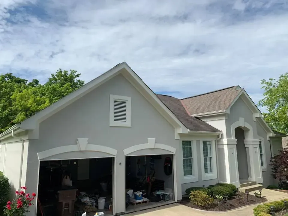 A large white house with a garage and a roof.