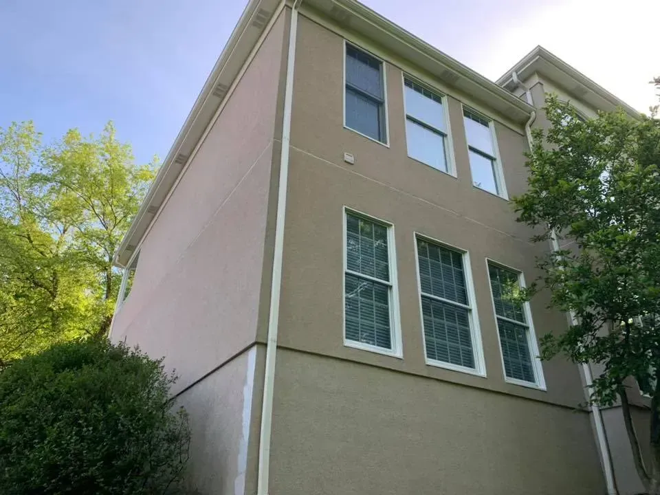 A house with a lot of windows and a blue sky in the background