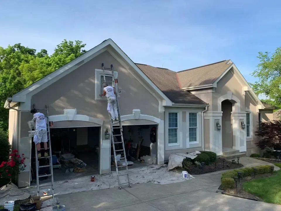 Two men are painting the outside of a house.