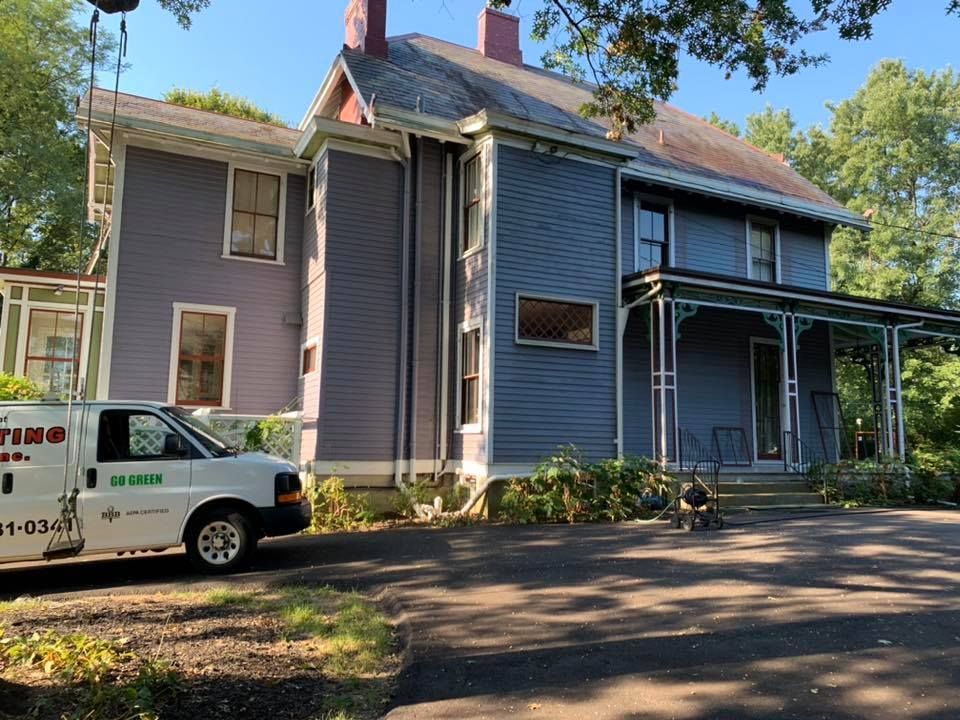 A white van is parked in front of a purple house