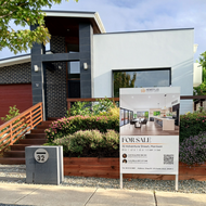 A house with a for sale sign in front of it