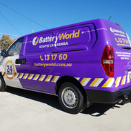 A purple battery world van is parked on the side of the road