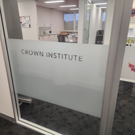 A glass door with the word crown institute on it
