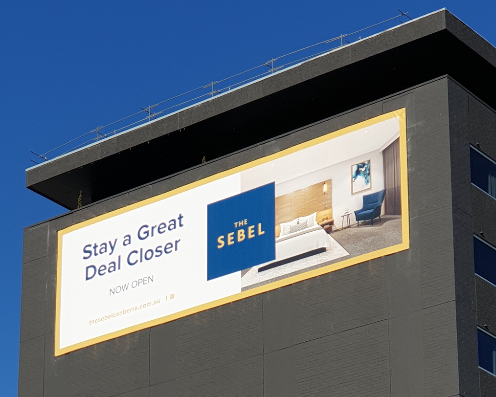 A billboard on the side of a building that says stay a great deal closer A billboard on the side of a building that says stay a great deal closer