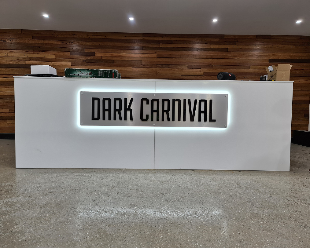 A white sign that says dark carnival on it