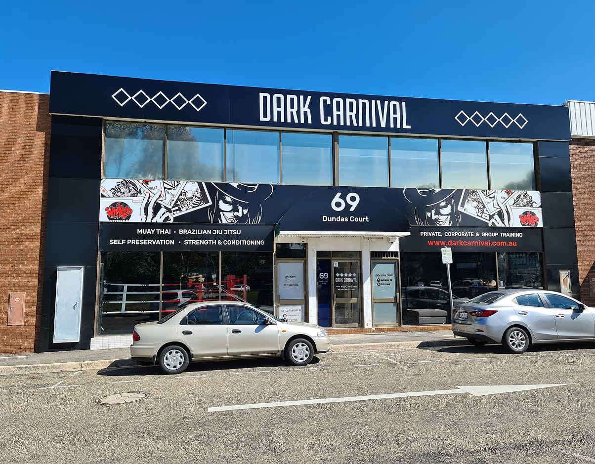 A car is parked in front of a dark carnival store A car is parked in front of a dark carnival store