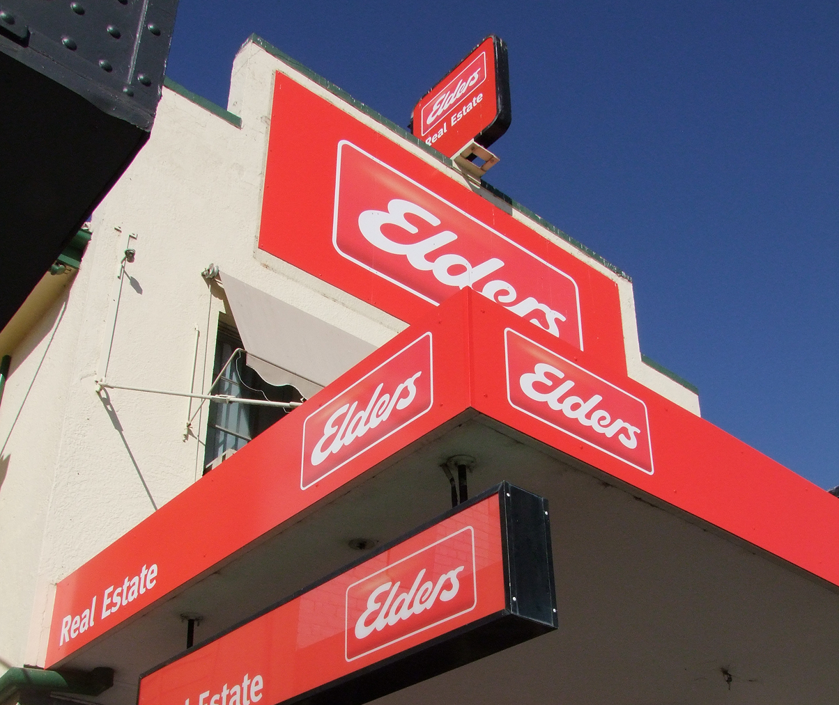 Elder 's real estate sign on the side of a building Elder 's real estate sign on the side of a building