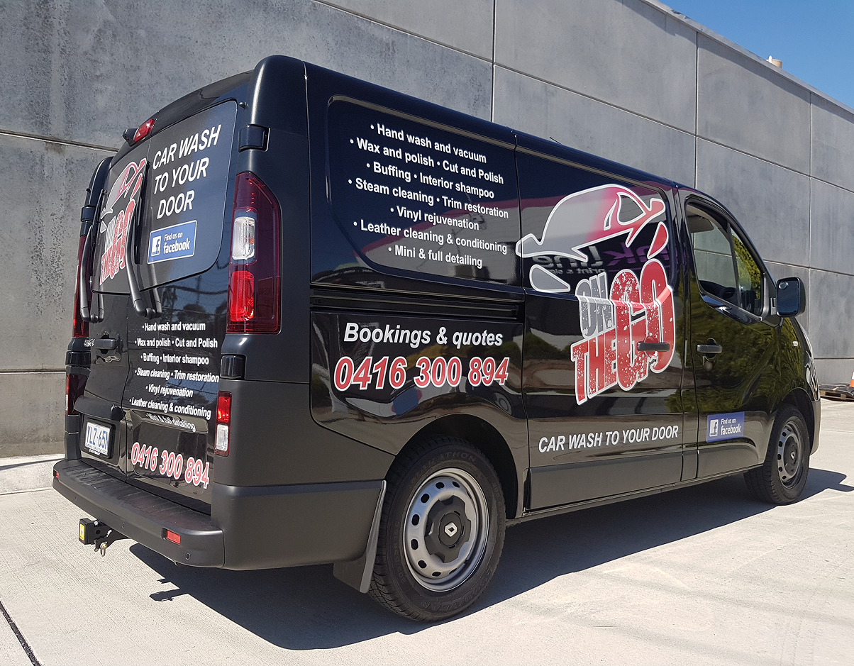 A black van is parked in front of a building. A black van is parked in front of a building.