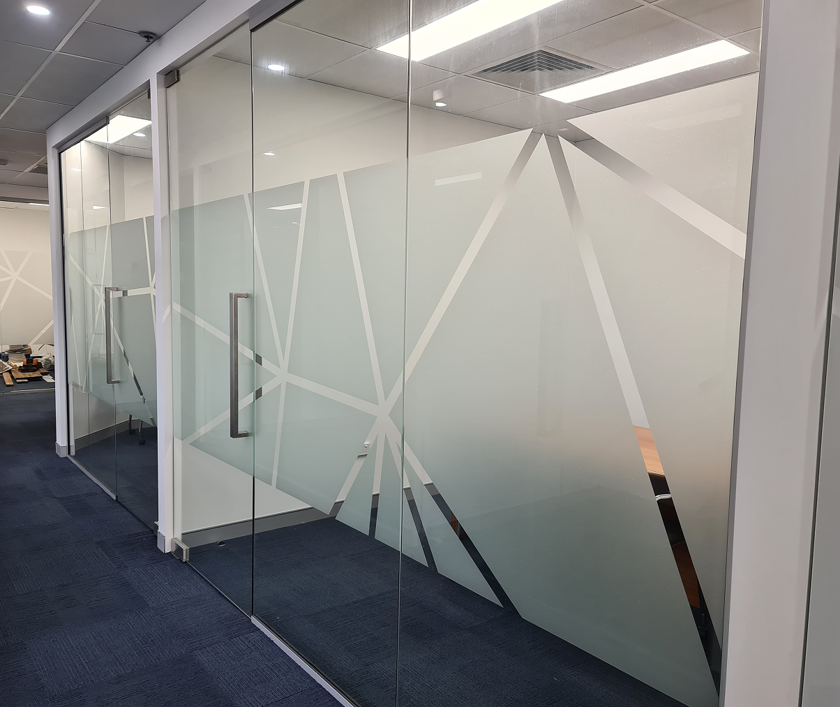 A glass wall with a geometric design on it. A glass wall with a geometric design on it.