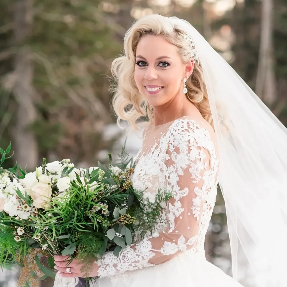 Bridesmaid helping the bride put on cowboy boots in a room with a mirror and couch.