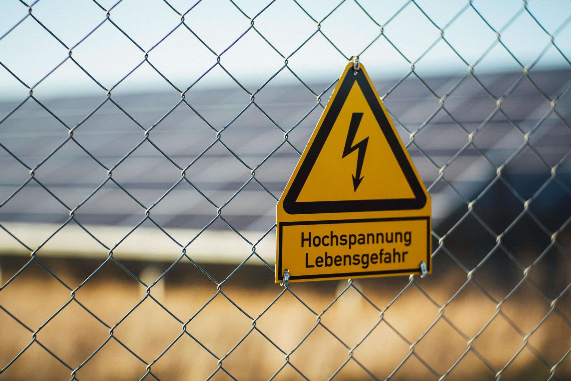 A sign on a chain link fence says hochspannung lebensgefahr