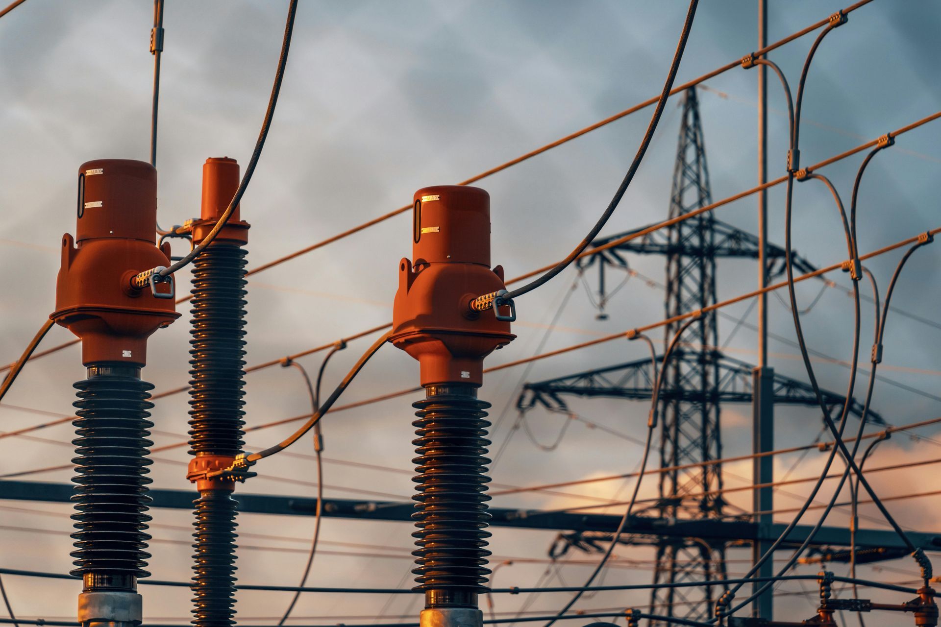A close up of a power line with a power tower in the background.