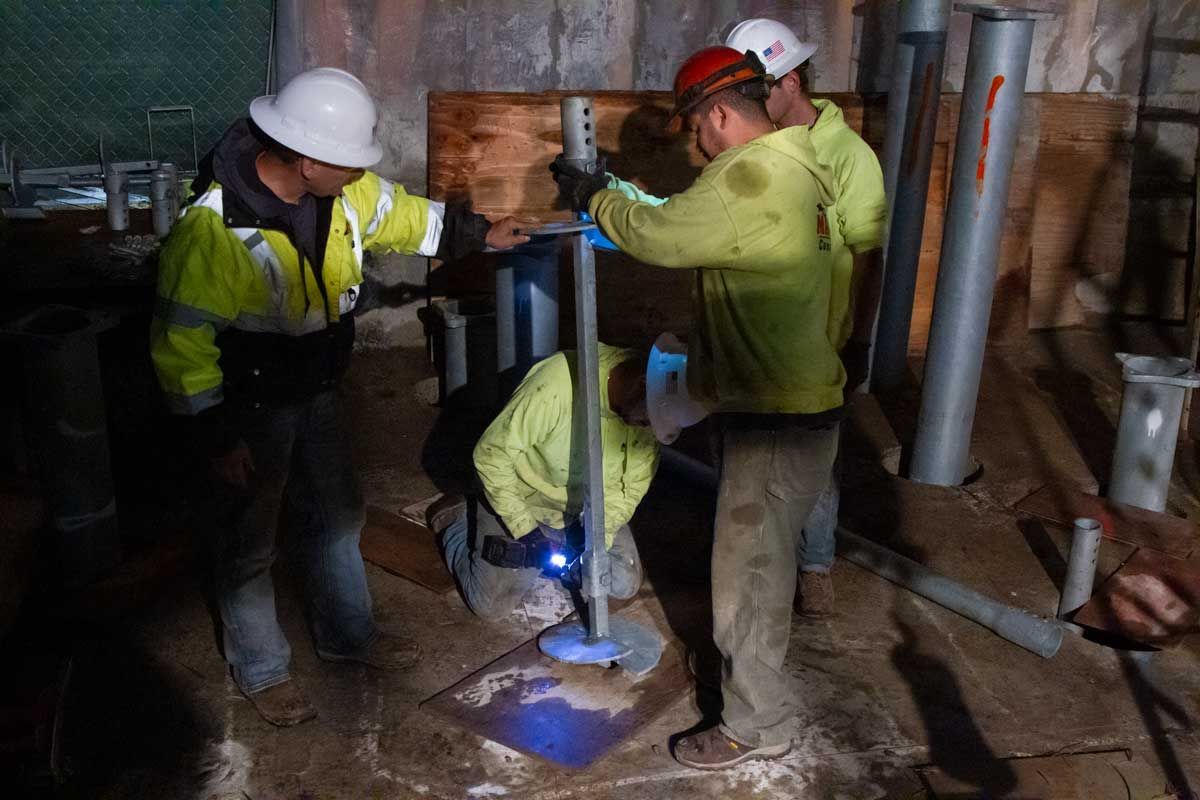 A group of construction workers are working on a pipe.