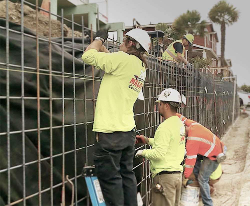 A group of construction workers are working on a wall