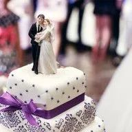 A wedding cake with a bride and groom figurine on top of it.