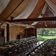 A long table and chairs inside of a barn.