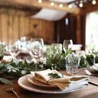 A table set for a dinner party with plates , glasses , and napkins.