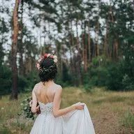 The bride is wearing a flower crown and holding a bouquet of flowers.