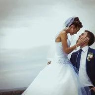 A bride and groom are kissing on their wedding day.