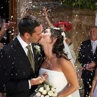 A bride and groom kissing in front of a crowd of people at their wedding.