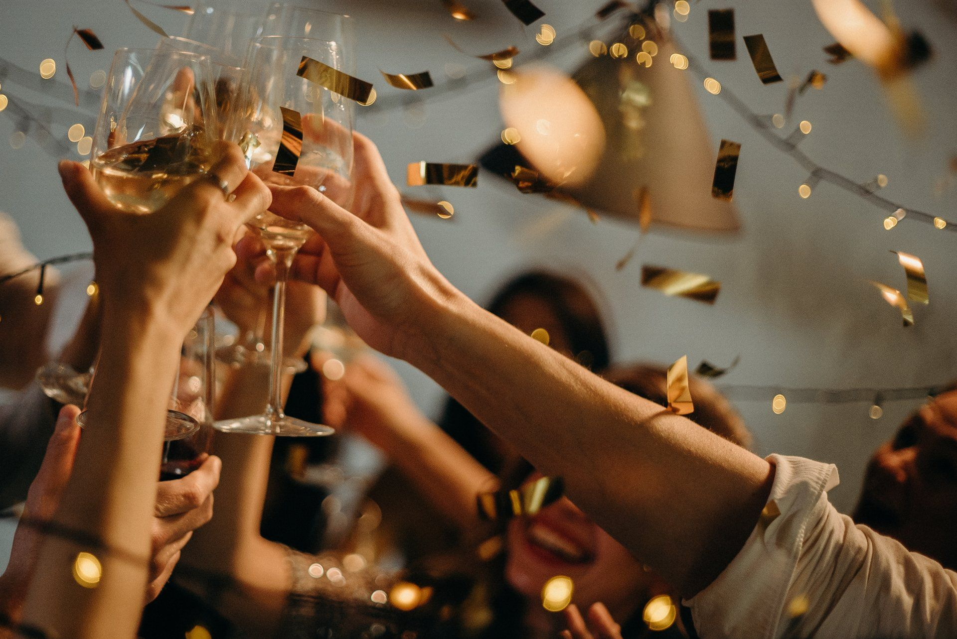 A group of people are toasting with wine glasses at a party.