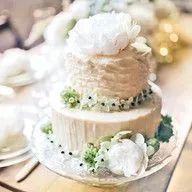 A wedding cake is sitting on top of a glass plate on a table.