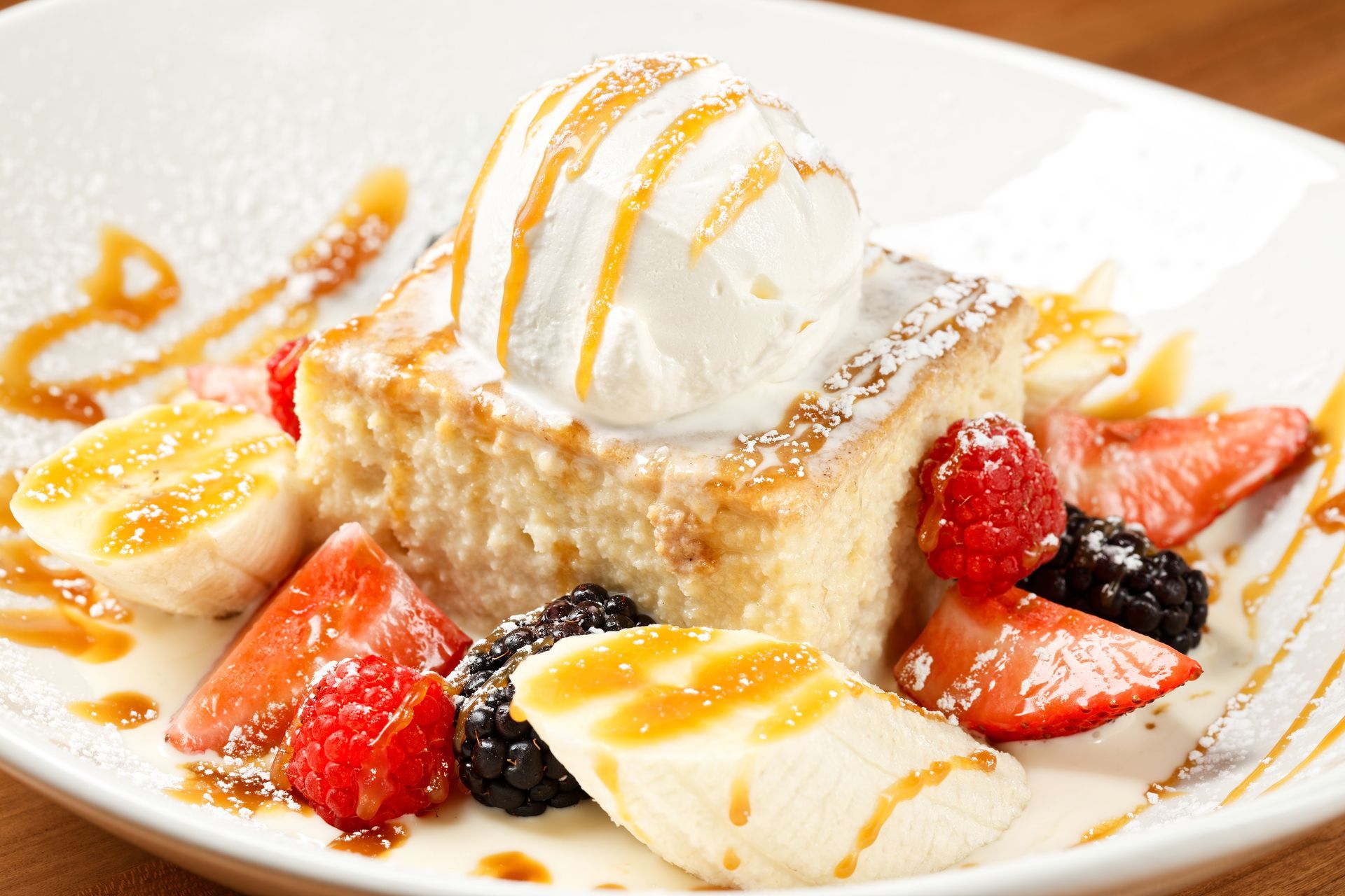 A dessert with ice cream and fruit on a white plate