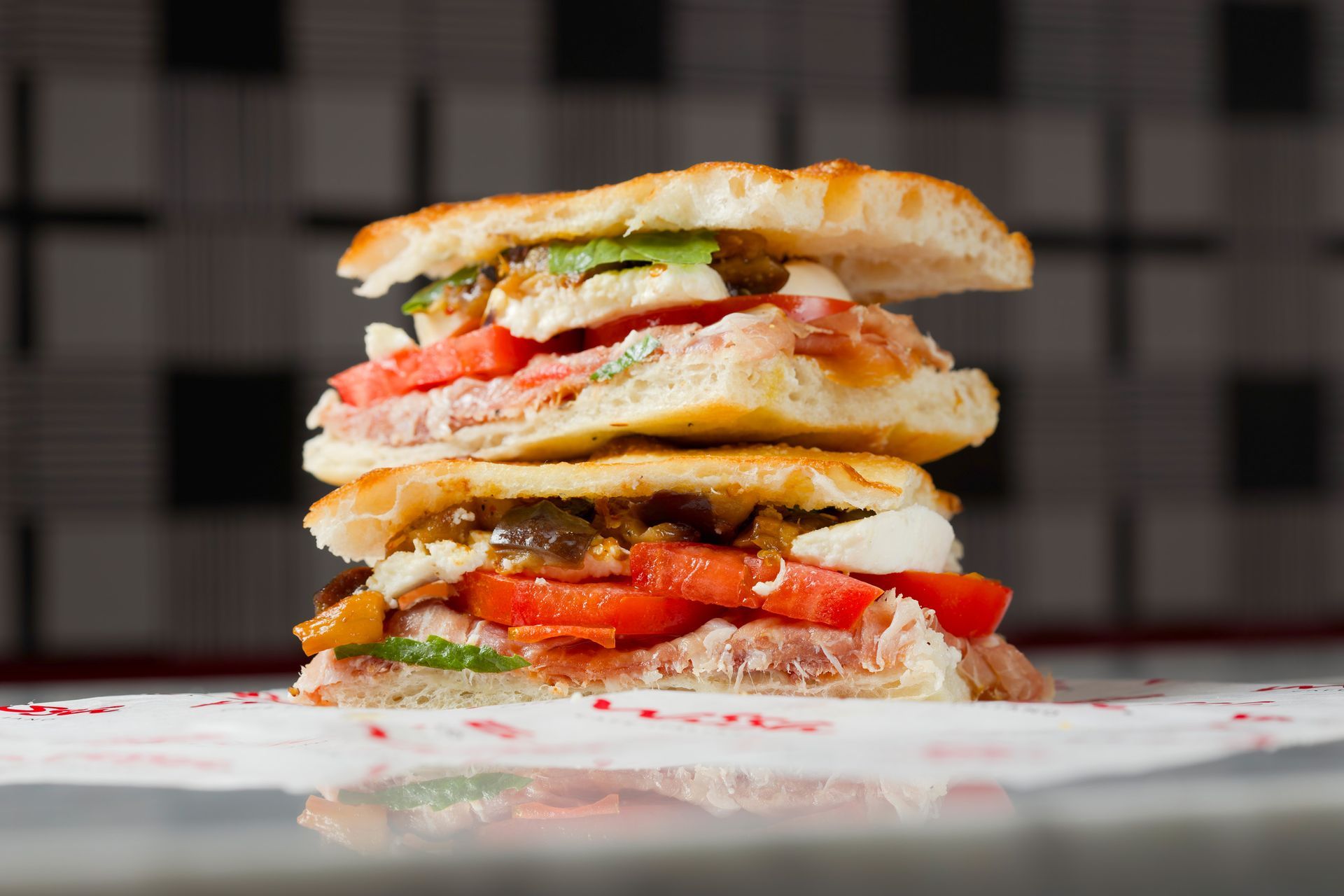 A sandwich is stacked on top of each other on a white plate.