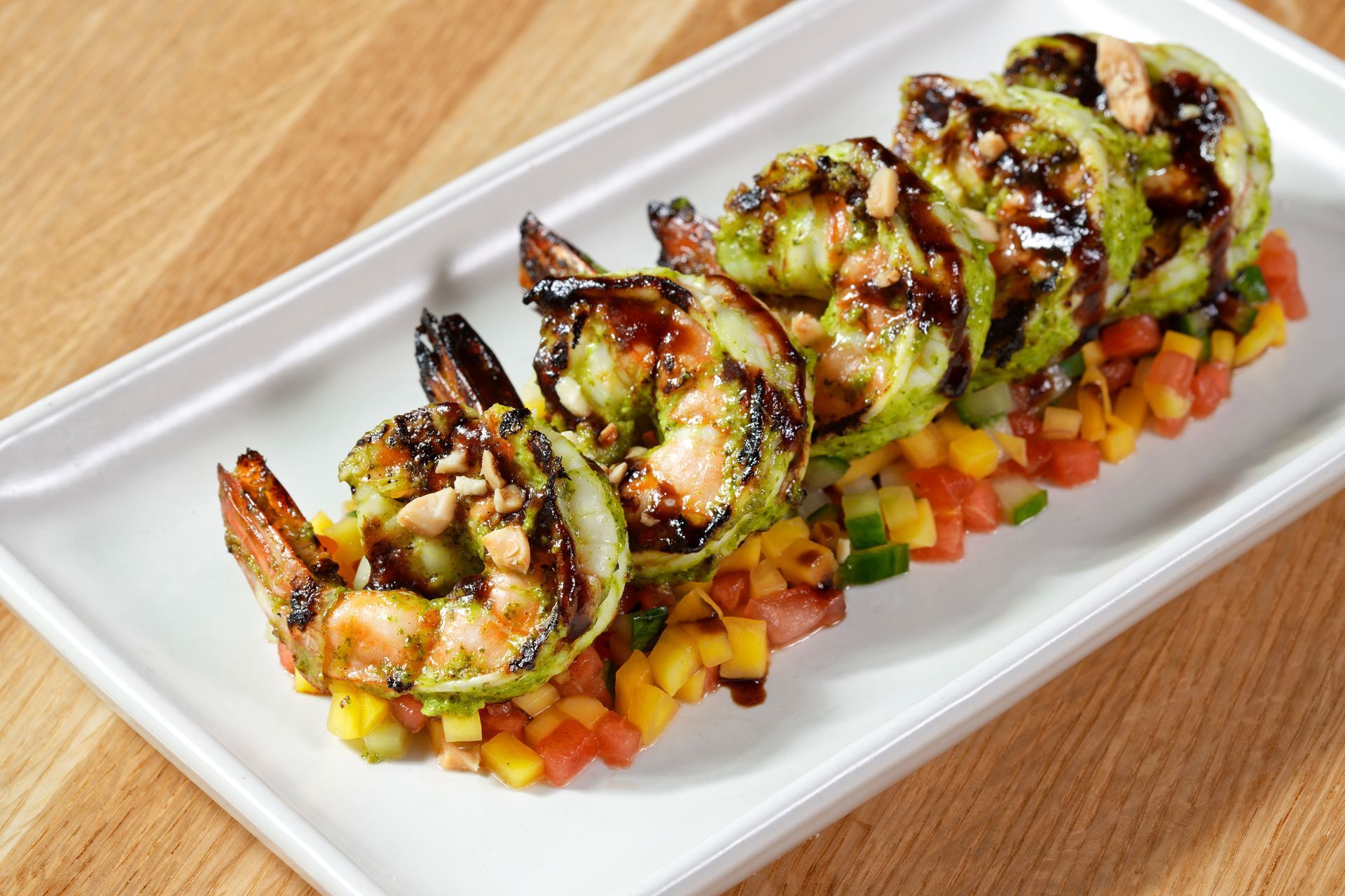 A white plate topped with shrimp and vegetables on a wooden table.