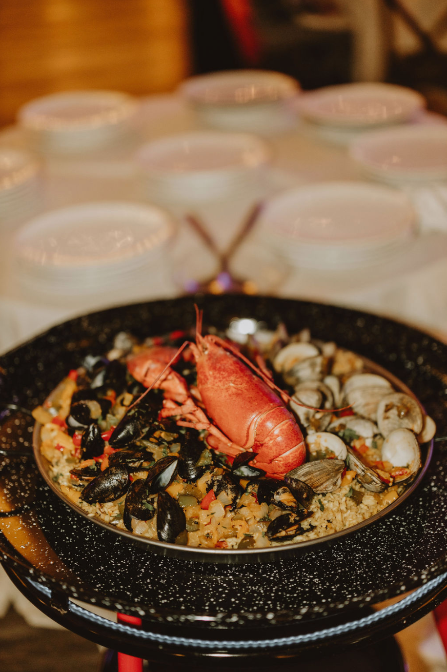 A close up of a paella with lobster and mussels on a table.