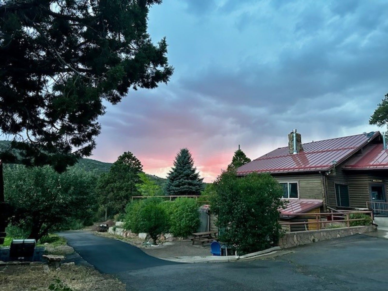 A house with a red roof and a sunset in the background