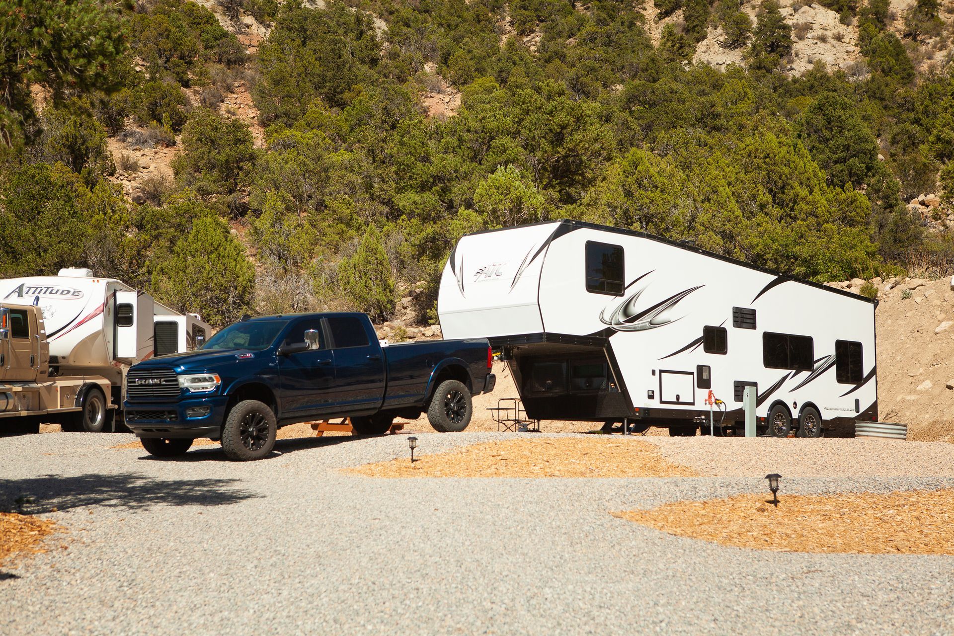 A truck is towing a trailer in a parking lot.