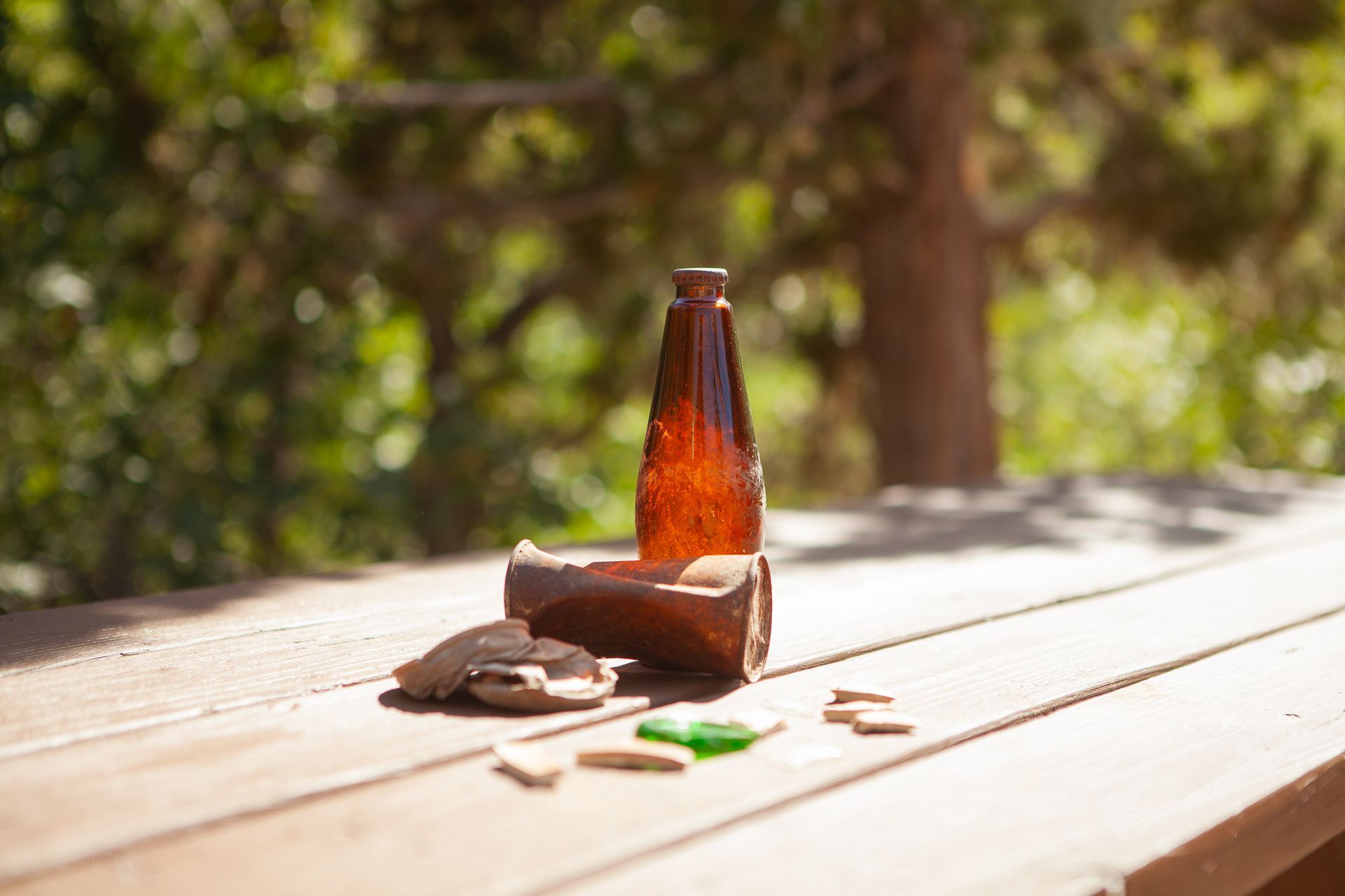 An empty beer bottle is sitting on a wooden table.