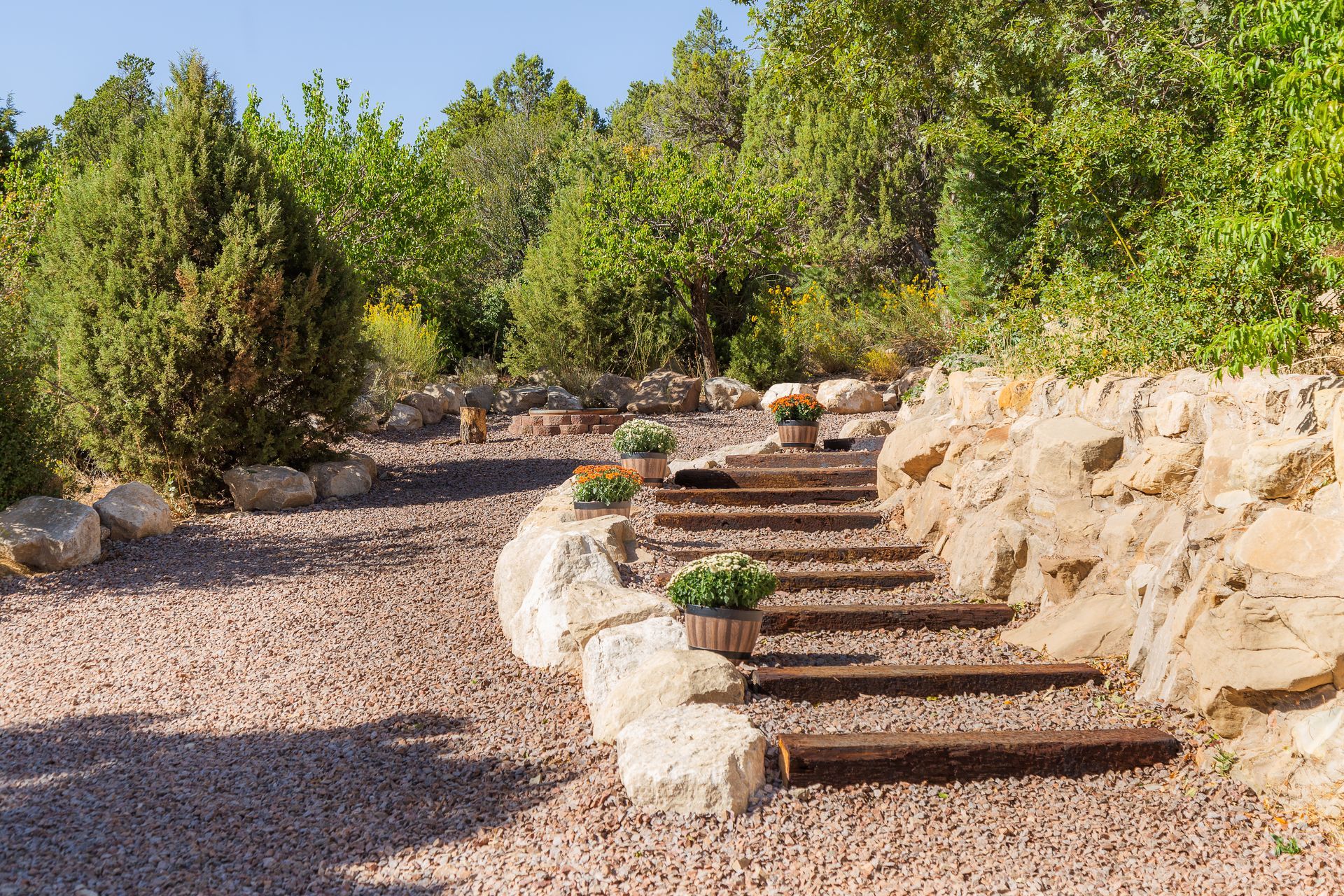 A wooden staircase leading up to a rock wall in a park.