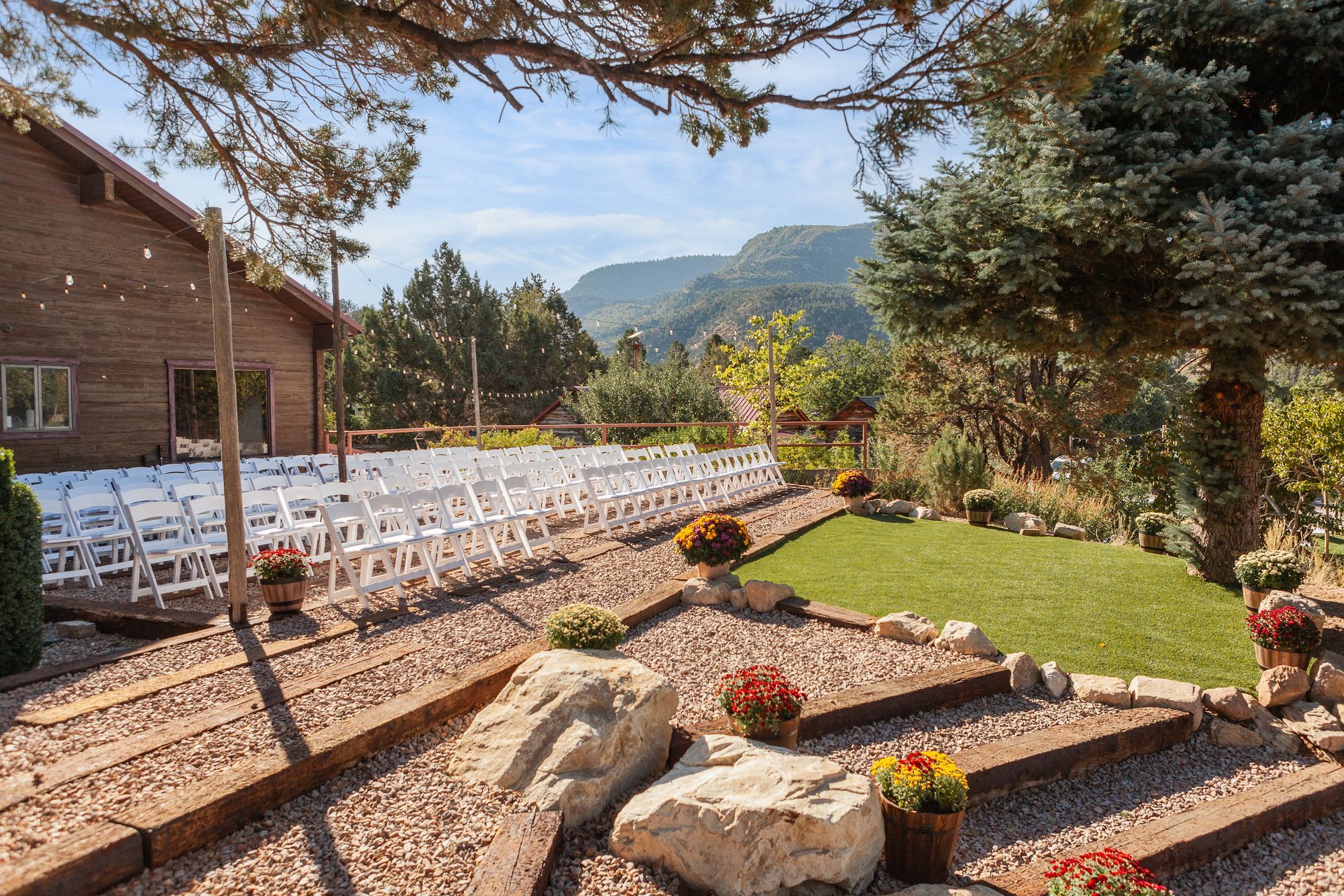 A row of white chairs are lined up in front of a building.