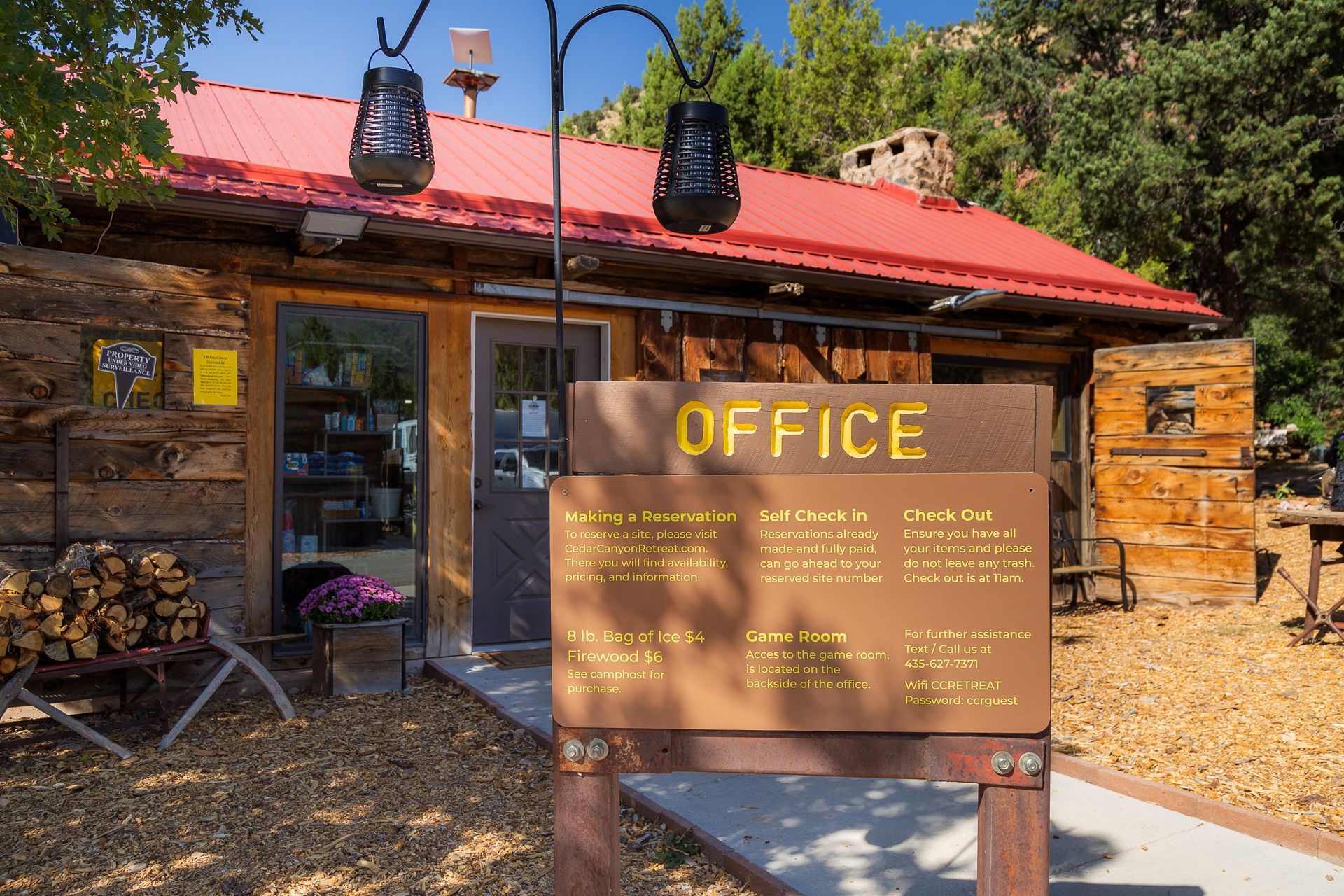 A wooden building with a red roof and a sign that says office