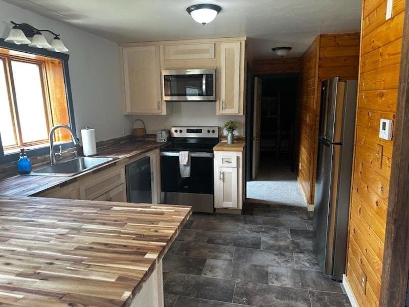 A kitchen with stainless steel appliances and wooden counter tops
