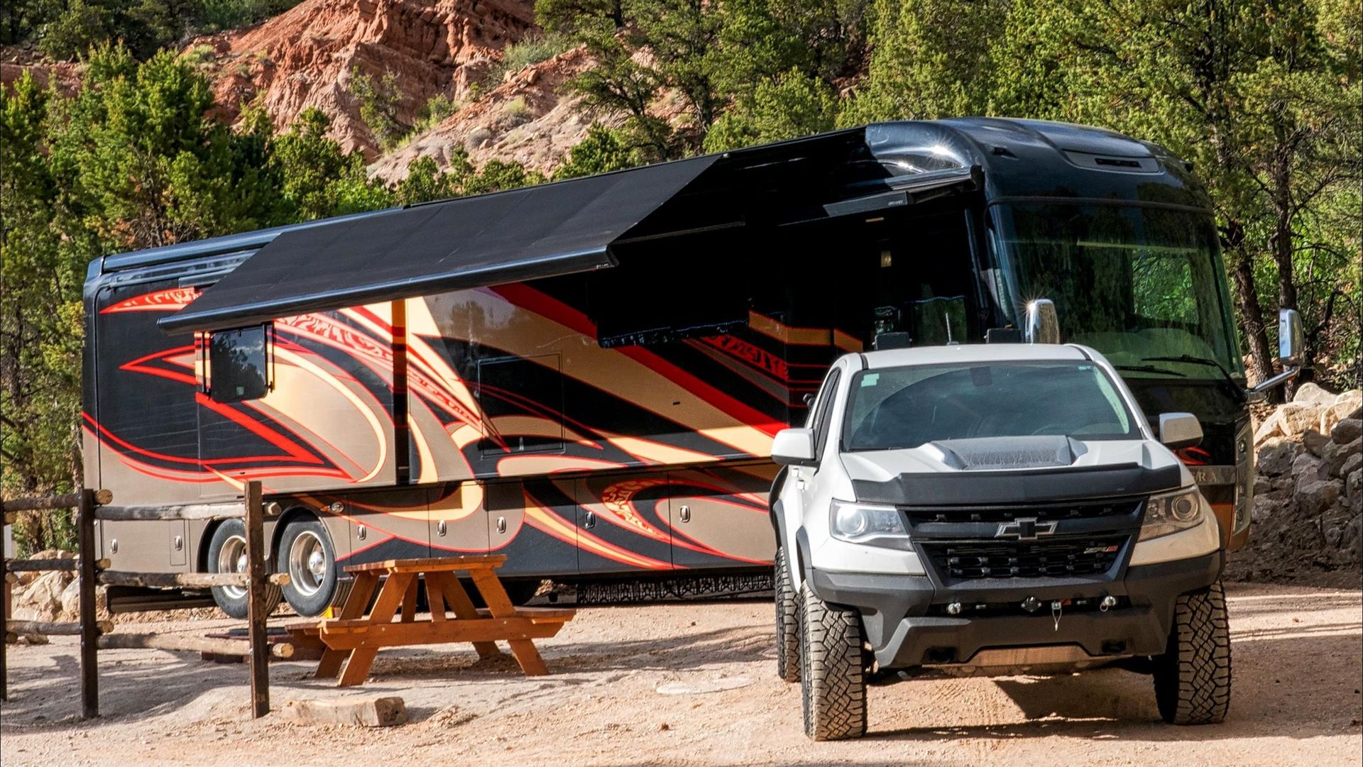 A truck is parked in front of a large rv.