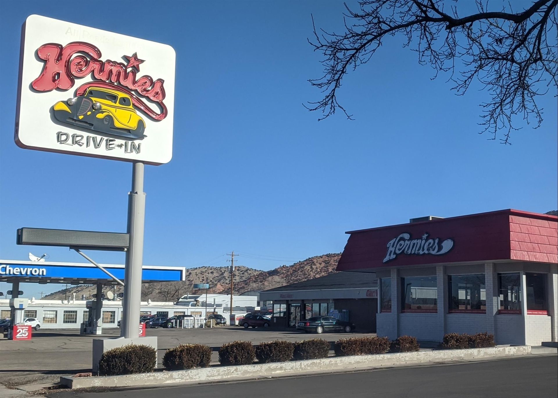 A drive-in restaurant with a large sign in front of it.