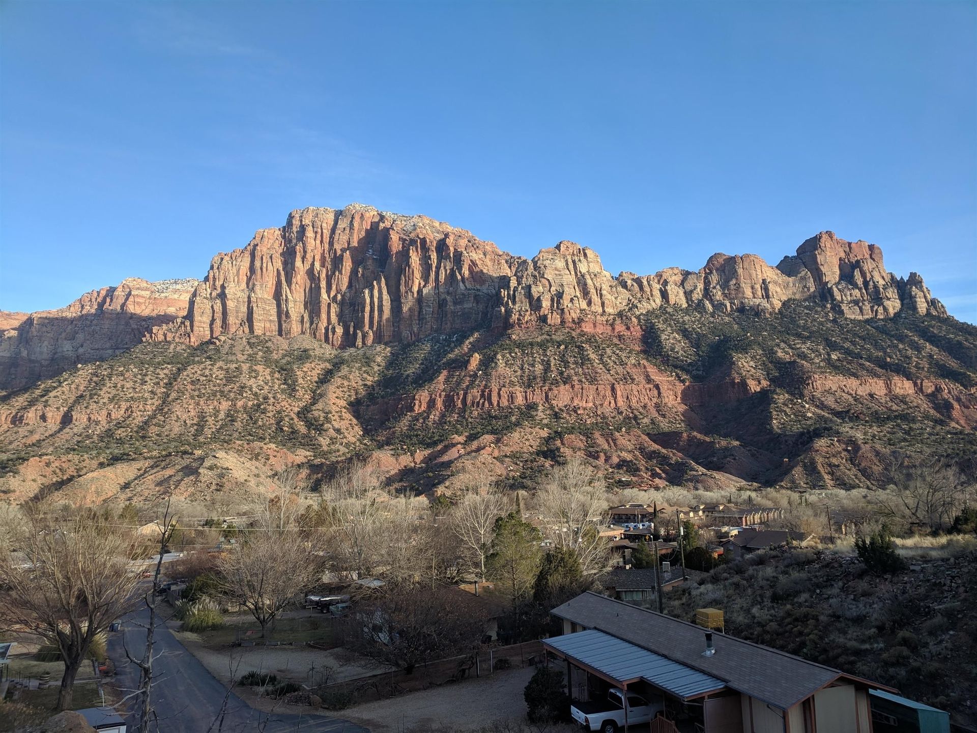 An aerial view of a mountain range with a house in the foreground.