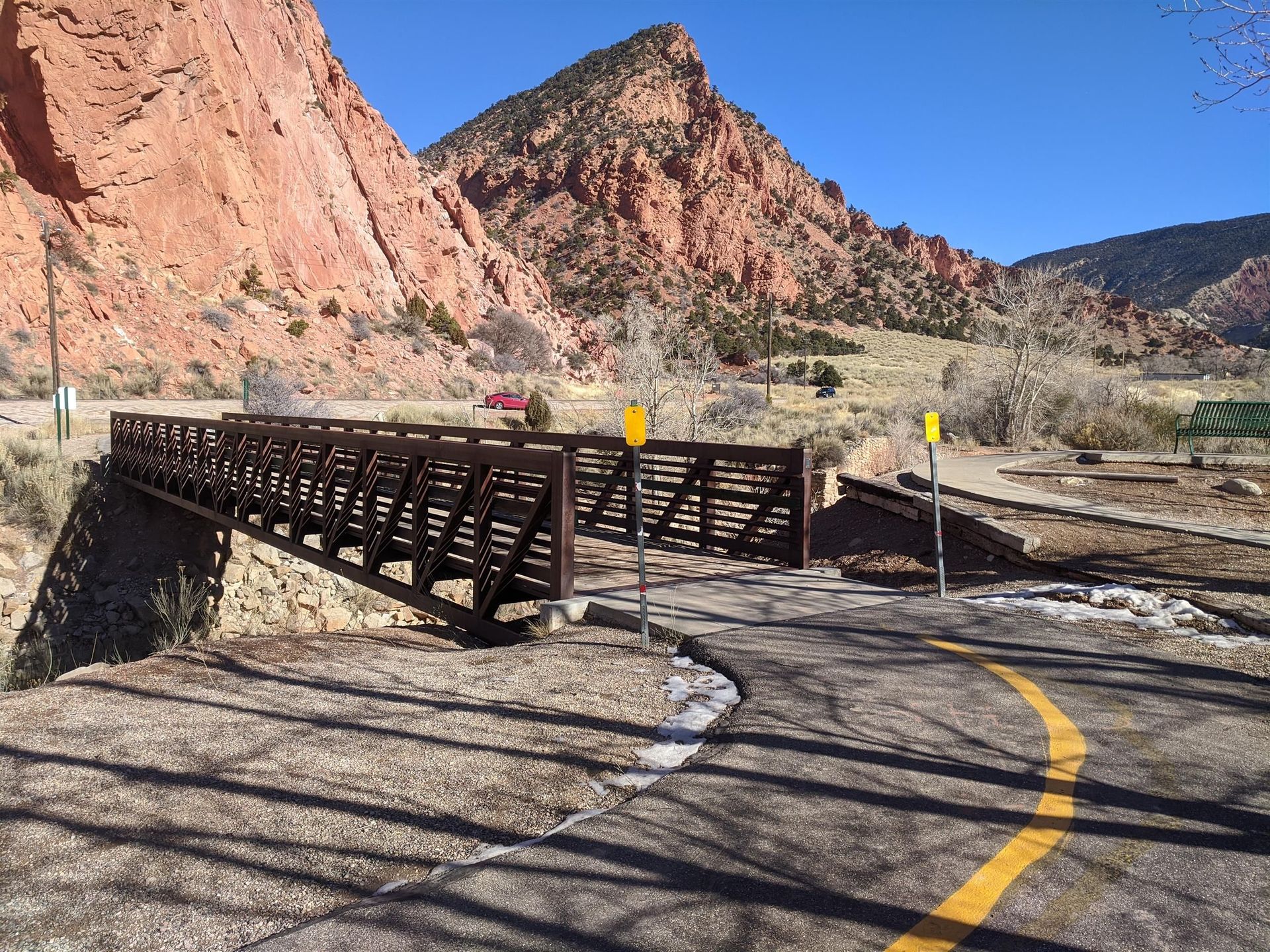 A bridge over a road with mountains in the background