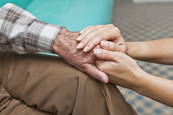 a woman is holding the hand of an older man .