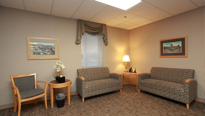 A waiting room with two couches and two chairs