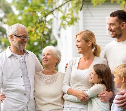 Family of six smiling, embracing outdoors in front of a house. GMS Legal & Conveyancing In 38 Canton Beach Rd, Toukley