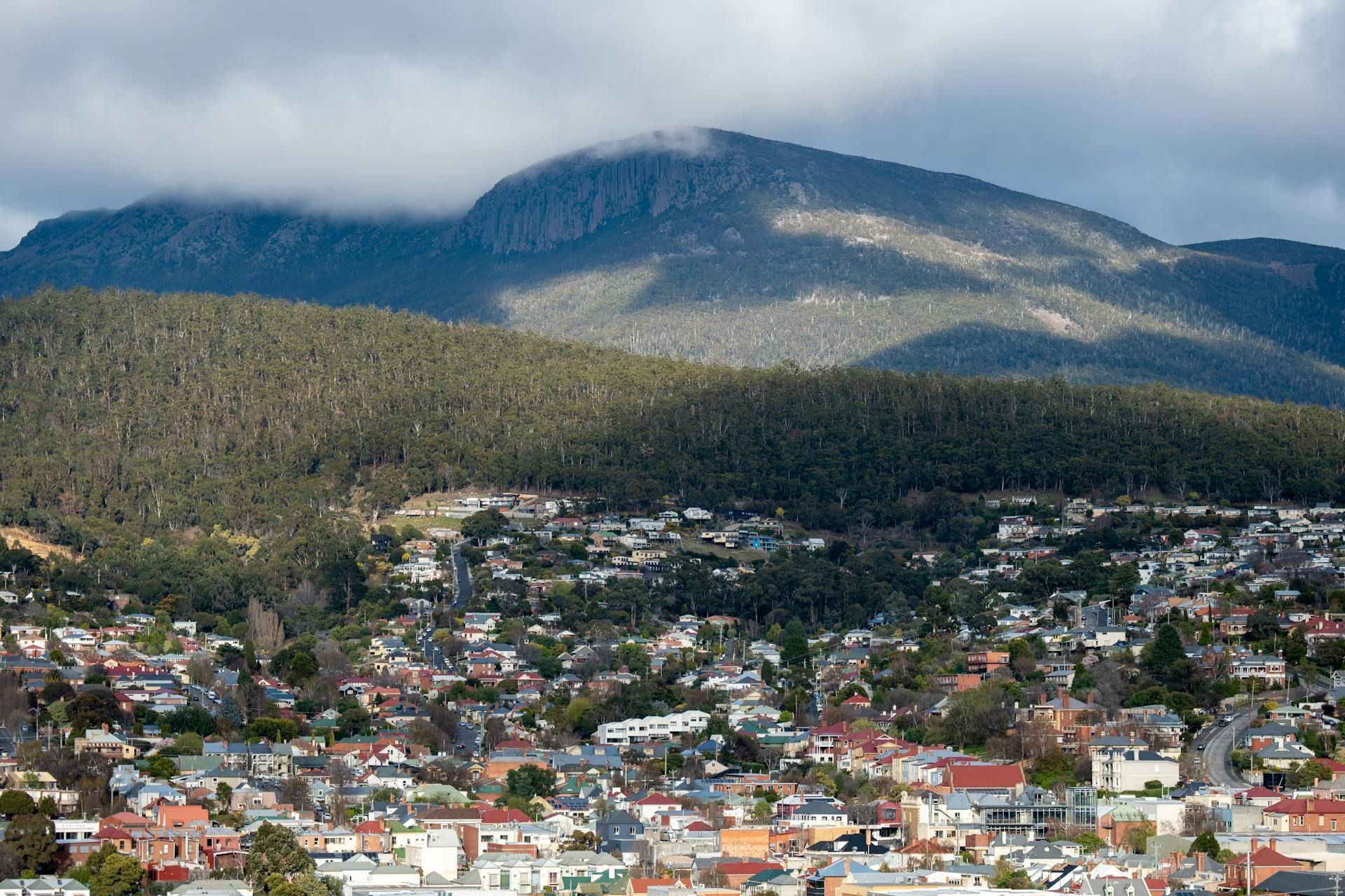 A Person Is Holding A Pair Of Keys In Front Of A House — GMS Legal & Conveyancing In Hunter Valley, NSW