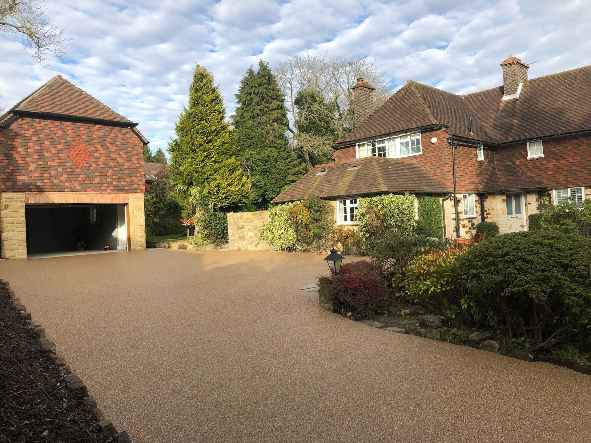 A large house with a garage and a gravel driveway in front of it.
