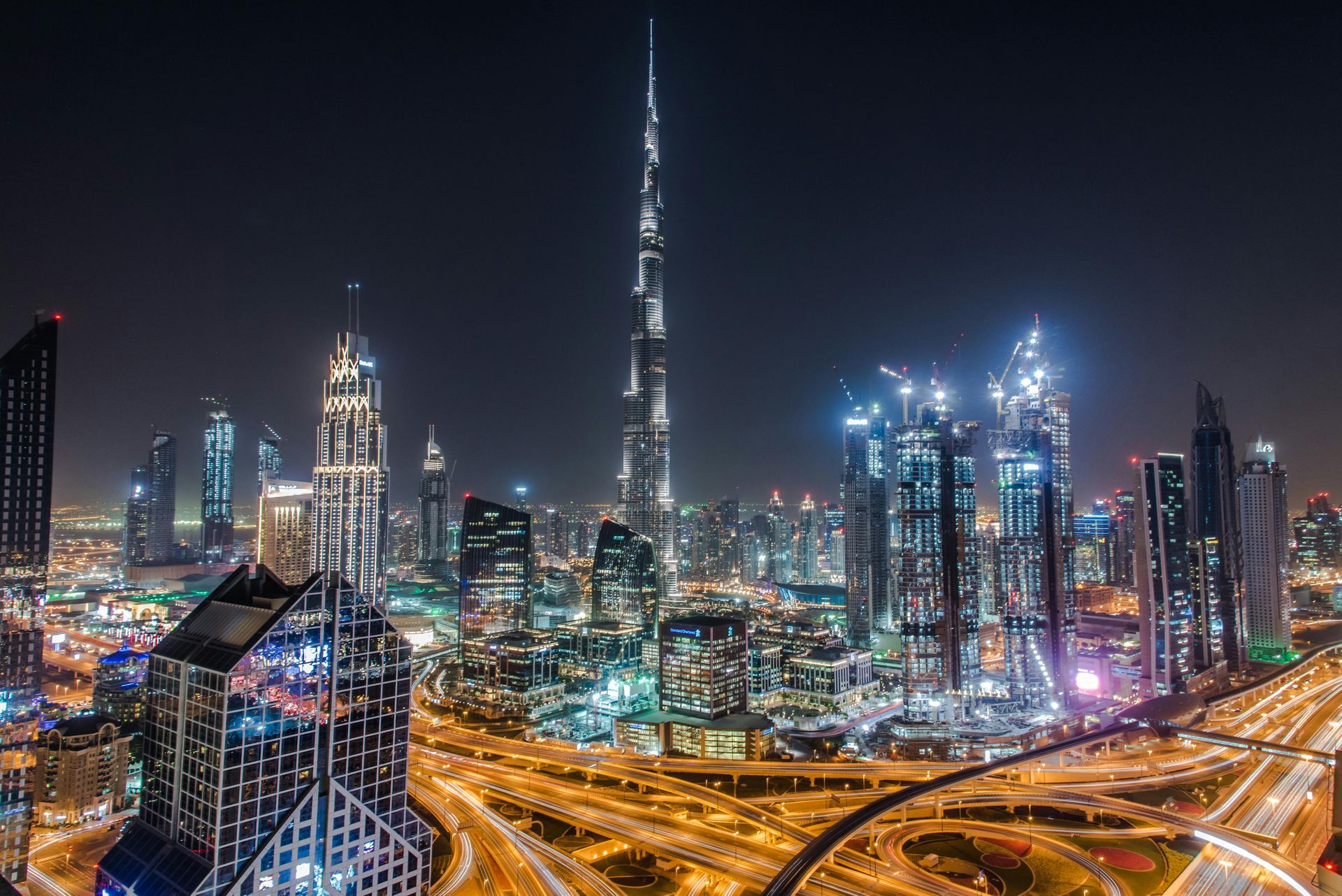 An aerial view of dubai
city at night with worlds tallest building in the foreground.