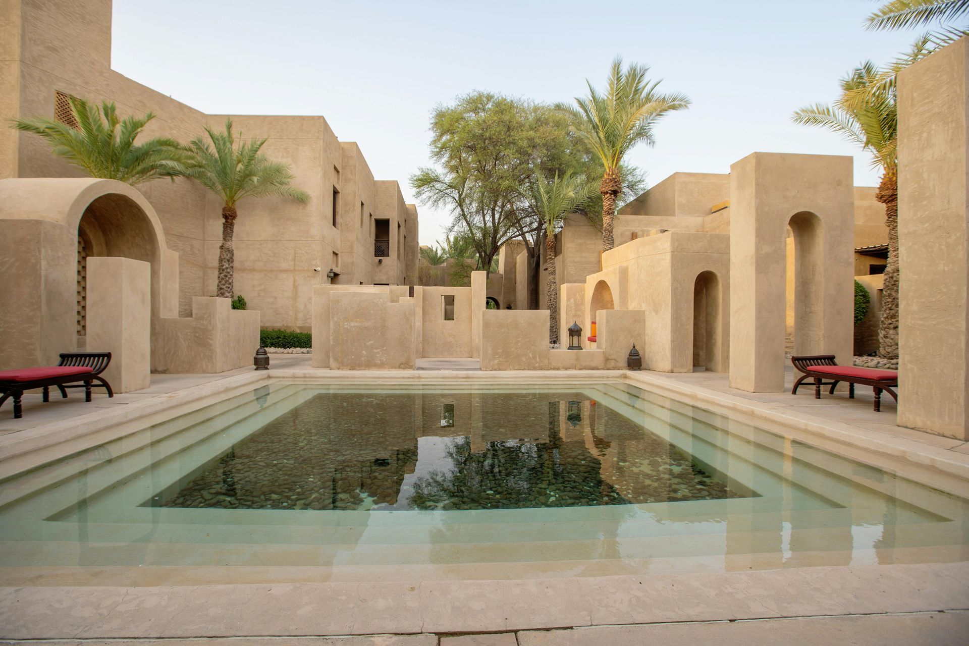 Image of a swimming pool with beautiful beige stone buildings for restex resin bound UAE